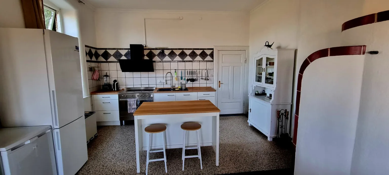 Geräumige Küche mit Kochinsel und altem Buffetschrank