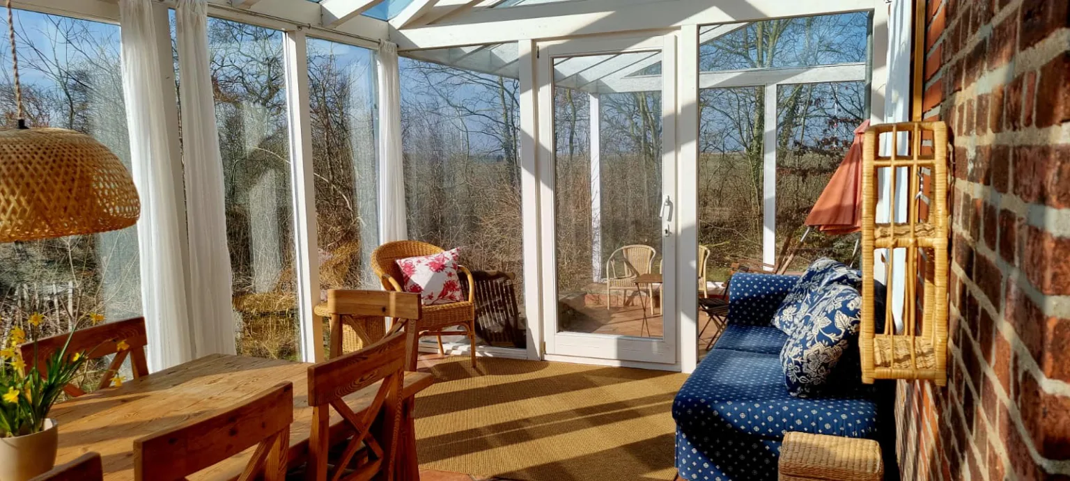 Sonniger Wintergarten mit Blick in die winterliche Natur