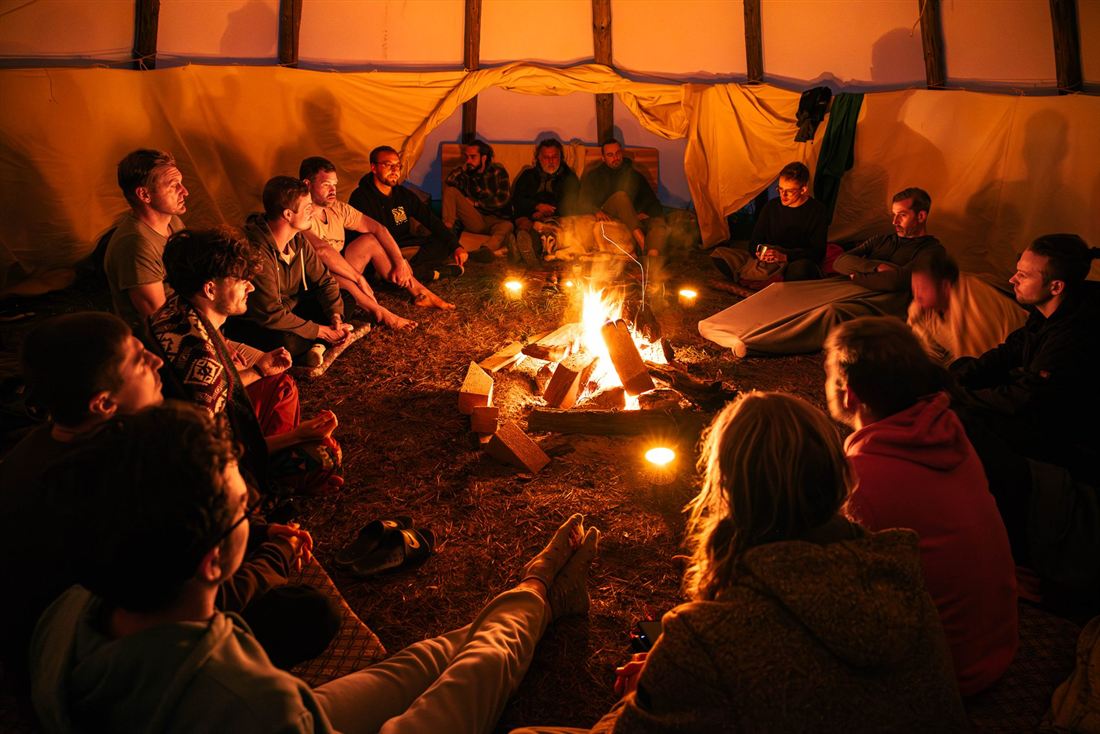 Männer im Kreis am Lagerfeuer
