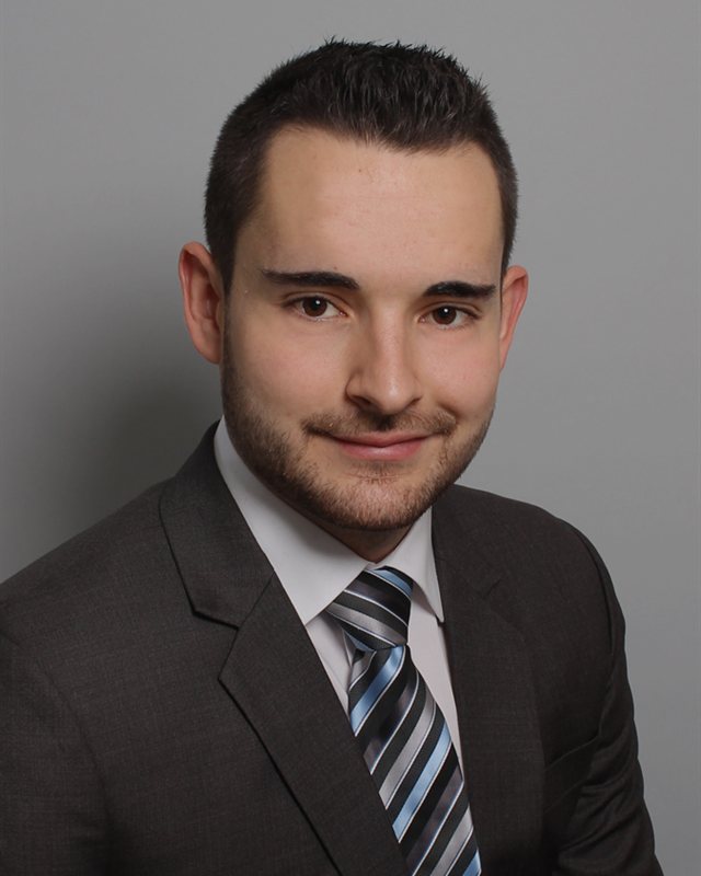 Michael im Anzug vor grauem Hintergrund, Bewerbungsfoto